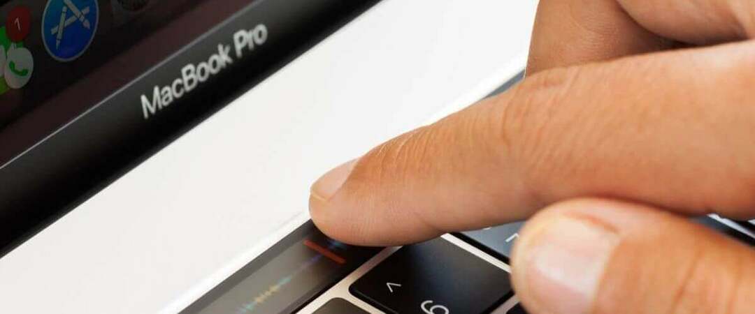 Lietotājs nospiež MacBook pogu